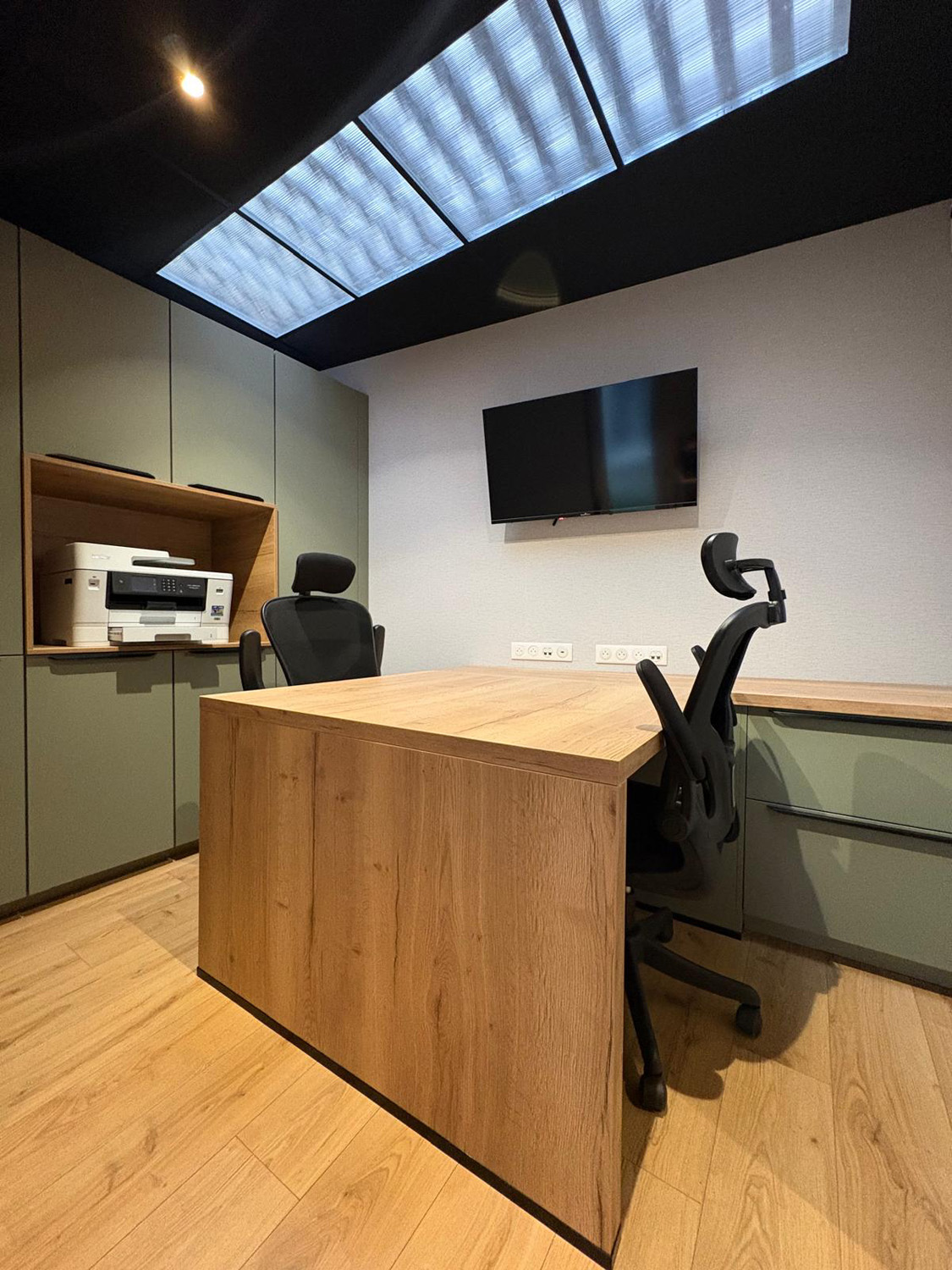 Vue d’ensemble d’un bureau professionnel avec mobilier sur mesure et éclairage plafond intégré